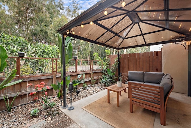 view of patio with a gazebo, an outdoor living space, and fence