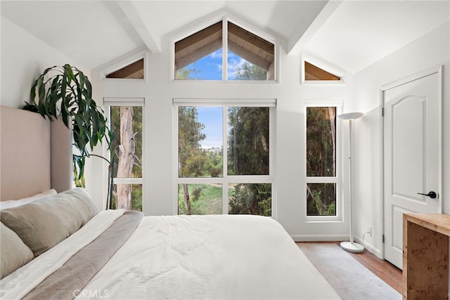 bedroom with vaulted ceiling with beams, baseboards, and wood finished floors