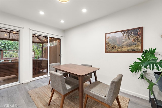 dining space featuring baseboards, recessed lighting, and wood finished floors