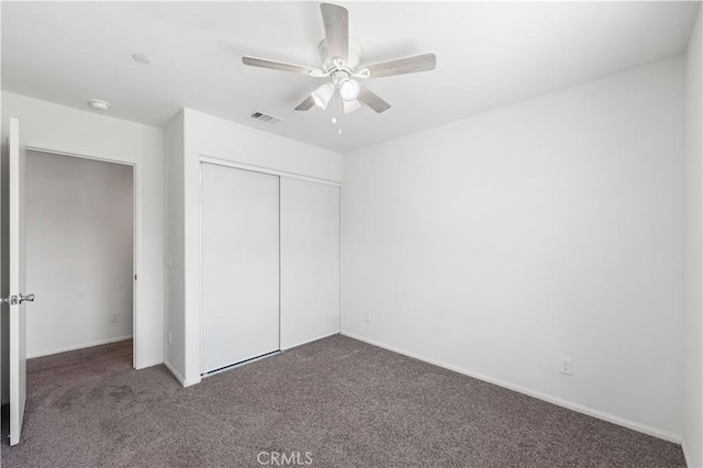 unfurnished bedroom featuring carpet floors, ceiling fan, visible vents, and a closet
