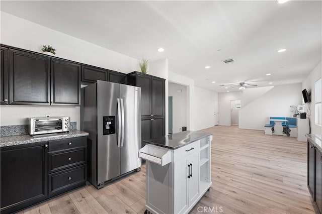 kitchen with a toaster, light wood-style floors, open floor plan, stainless steel fridge, and recessed lighting