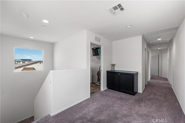 hall with carpet floors, visible vents, attic access, and an upstairs landing