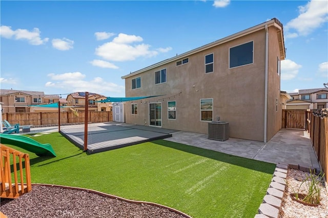 back of house with a fenced backyard, a patio, stucco siding, and central AC
