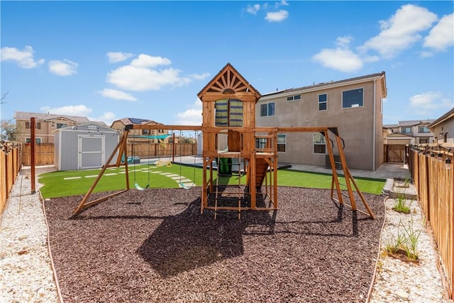 view of playground with an outdoor structure, a fenced backyard, and a shed