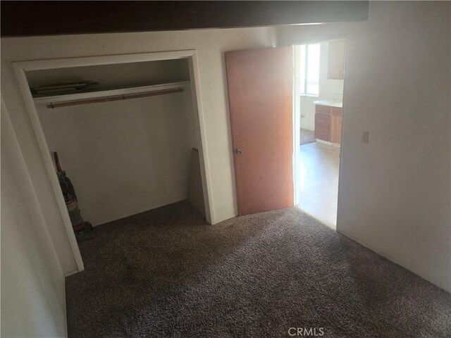 unfurnished bedroom featuring carpet and a closet