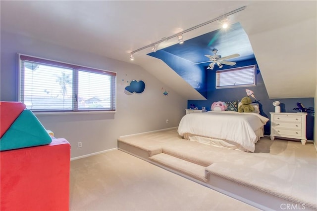 bedroom featuring lofted ceiling, carpet flooring, baseboards, ceiling fan, and rail lighting