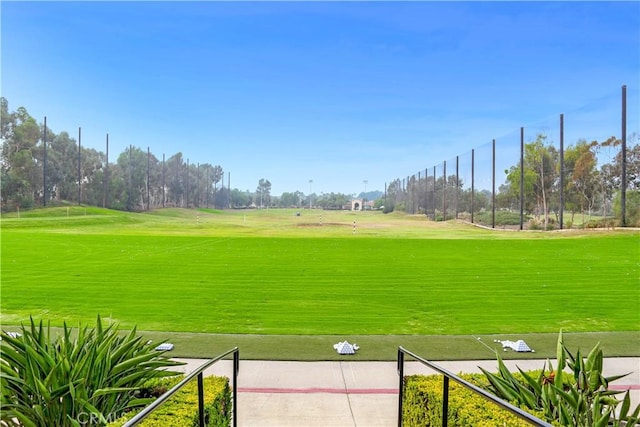view of community with golf course view and a yard