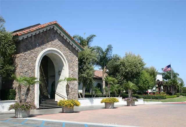 exterior space with a tile roof and stone siding