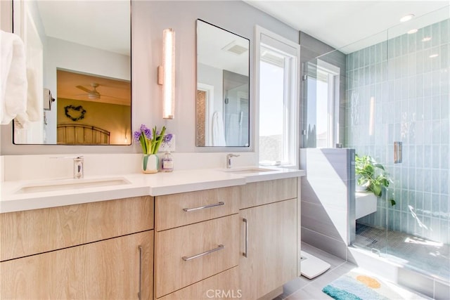 bathroom featuring double vanity, a sink, a stall shower, and tile patterned flooring