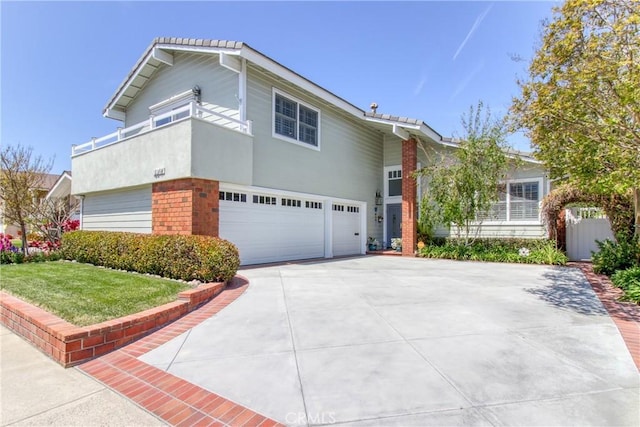 split level home featuring a garage, a front lawn, stucco siding, brick siding, and concrete driveway