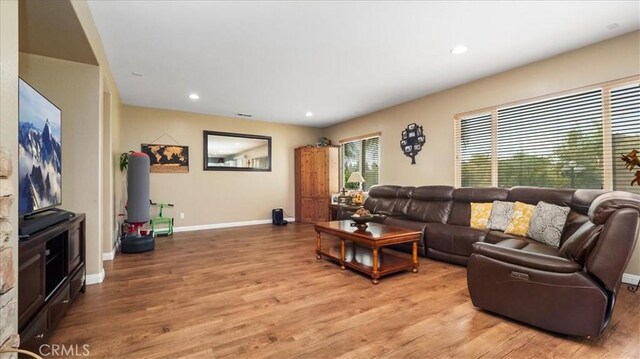 living area featuring baseboards, recessed lighting, and light wood-style flooring