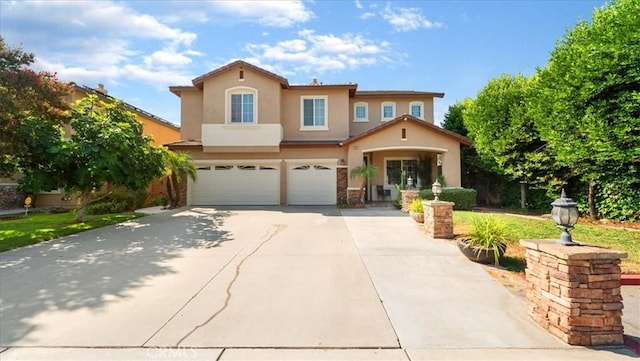 mediterranean / spanish-style home featuring a garage, stucco siding, and driveway