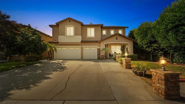 mediterranean / spanish-style house with concrete driveway, a garage, and stucco siding