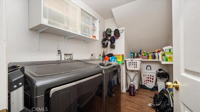 washroom featuring separate washer and dryer, laundry area, and wood finished floors