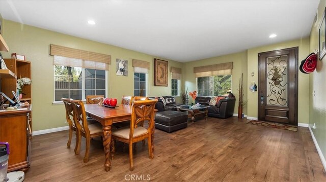 dining room with a healthy amount of sunlight, baseboards, and wood finished floors