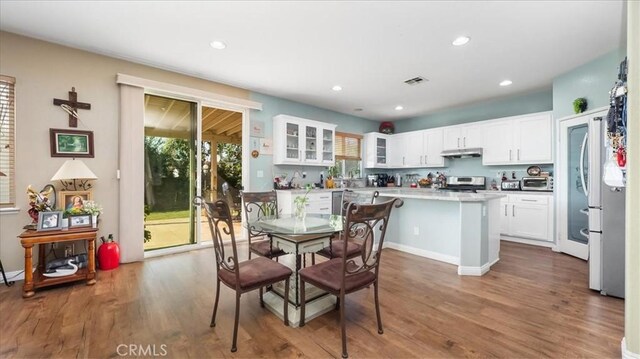 dining room featuring visible vents, plenty of natural light, and wood finished floors