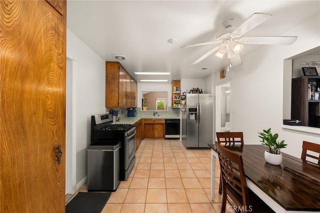 8757 San Vicente Ave, Riverside, CA 92503 - kitchen featuring appliances with stainless steel finishes, a sink, light tile patterned flooring, brown cabinets, and a ceiling fan