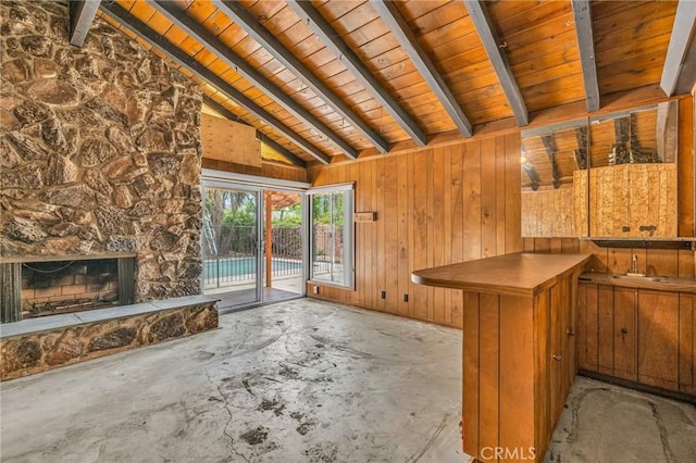 7038 Mclennan Ave, Lake Balboa, CA 91406 - unfurnished living room featuring wood walls, a fireplace, vaulted ceiling with beams, wooden ceiling, and unfinished concrete flooring