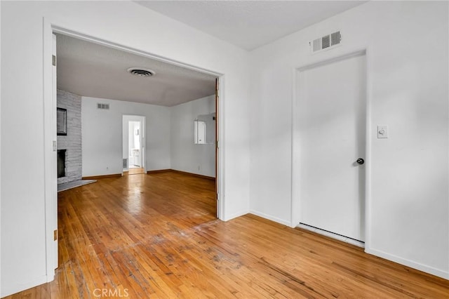 7038 Mclennan Ave, Lake Balboa, CA 91406 - empty room with visible vents, hardwood / wood-style floors, and a large fireplace