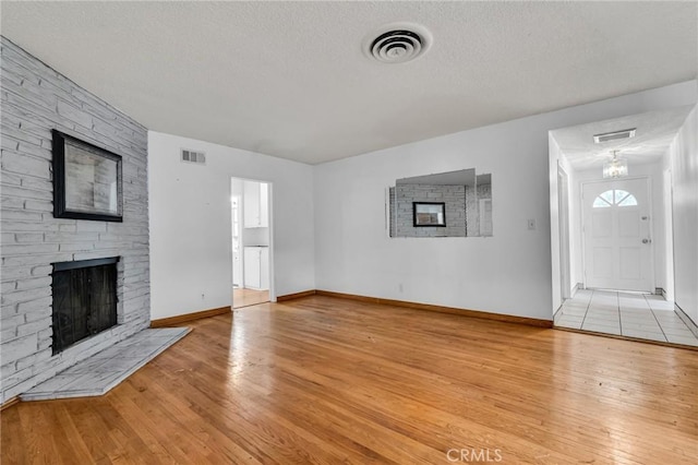 7038 Mclennan Ave, Lake Balboa, CA 91406 - unfurnished living room with visible vents, a textured ceiling, hardwood / wood-style floors, and a fireplace