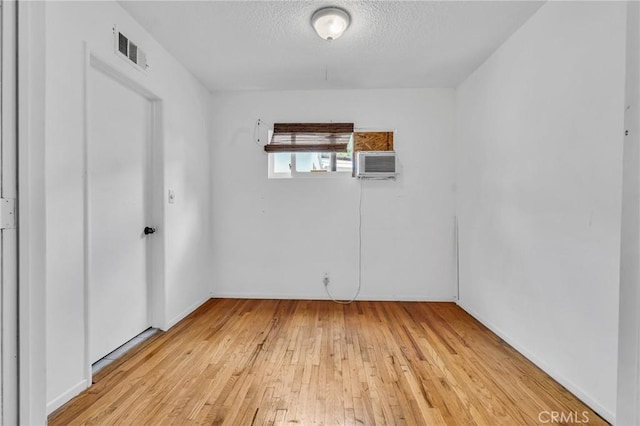 7038 Mclennan Ave, Lake Balboa, CA 91406 - spare room featuring visible vents, baseboards, an AC wall unit, light wood-type flooring, and a textured ceiling
