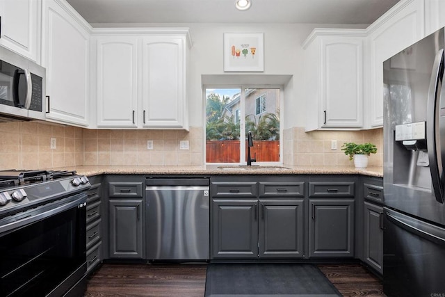 kitchen with gray cabinetry, appliances with stainless steel finishes, white cabinets, and a sink