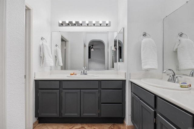 full bathroom featuring a ceiling fan, tile patterned floors, two vanities, and a sink
