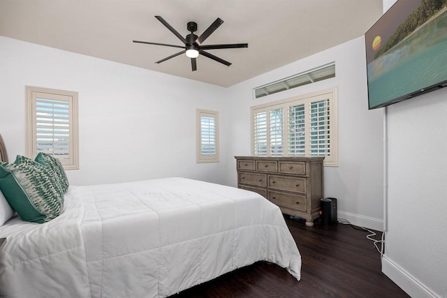 bedroom with baseboards, multiple windows, ceiling fan, and dark wood-type flooring