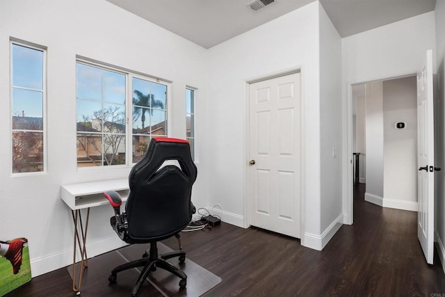 office space with dark wood-type flooring, baseboards, and visible vents