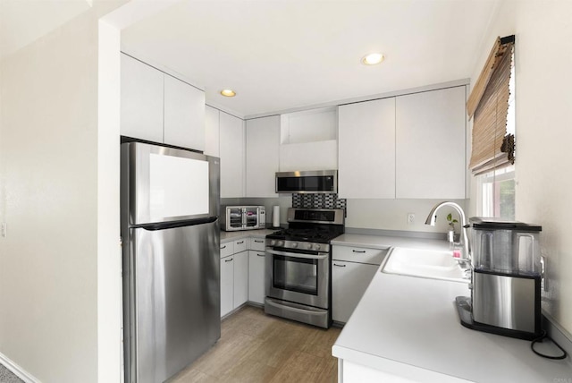 1265 Dawnridge Ave, El Cajon, CA 92021 - kitchen featuring appliances with stainless steel finishes, a sink, recessed lighting, white cabinets, and light wood finished floors