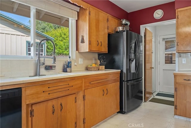 kitchen featuring fridge with ice dispenser, backsplash, black dishwasher, and light floors
