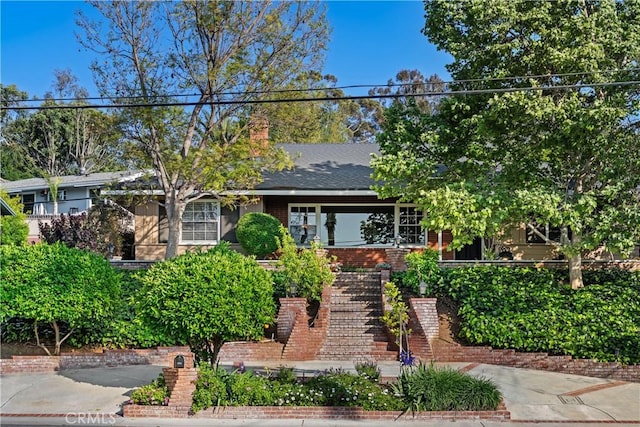 view of front of home featuring stairs and brick siding