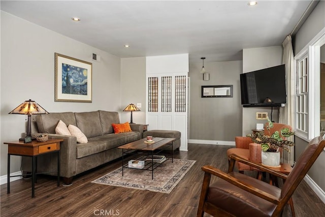 living area featuring baseboards and wood finished floors