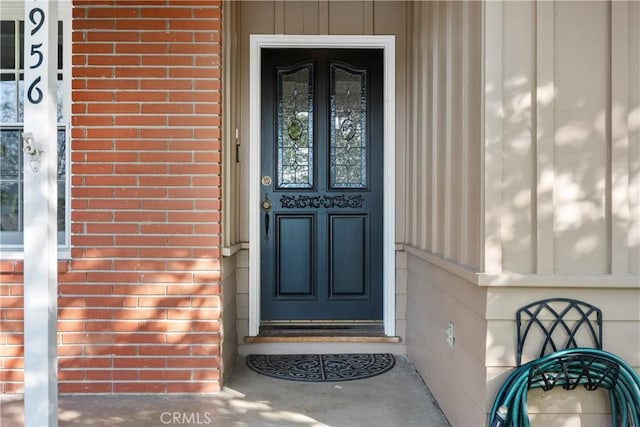 doorway to property featuring brick siding