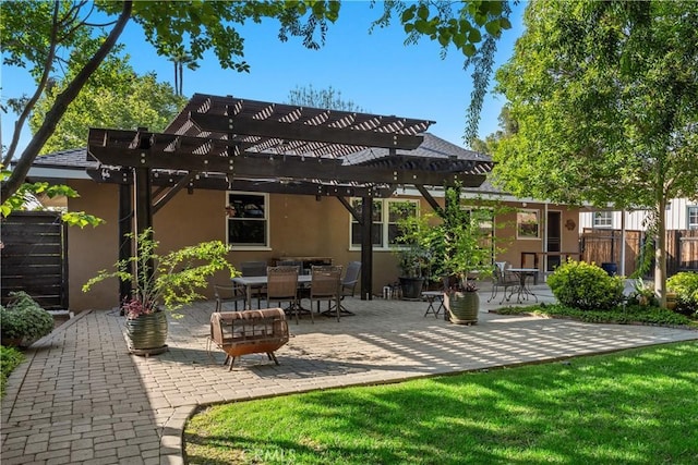 rear view of house with fence, a pergola, stucco siding, a patio area, and a lawn