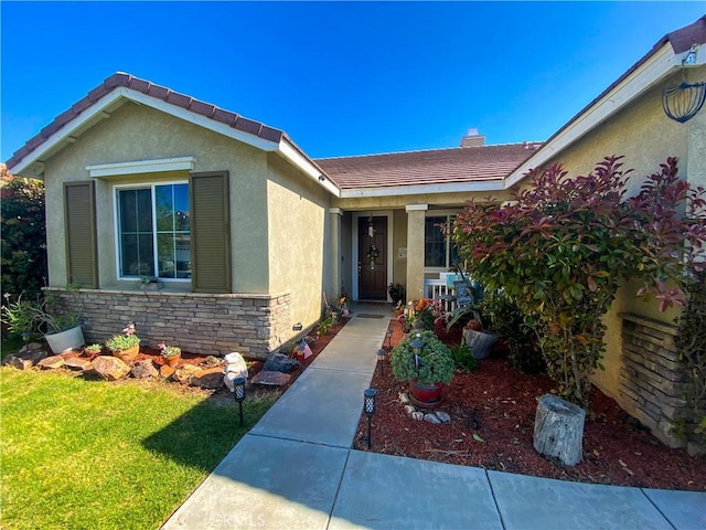 1436 Saddlebrook Way, San Jacinto, CA 92582 - doorway to property featuring stucco siding, a yard, stone siding, and a tile roof