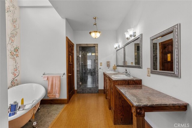 full bathroom with vanity, baseboards, a freestanding bath, and a stall shower