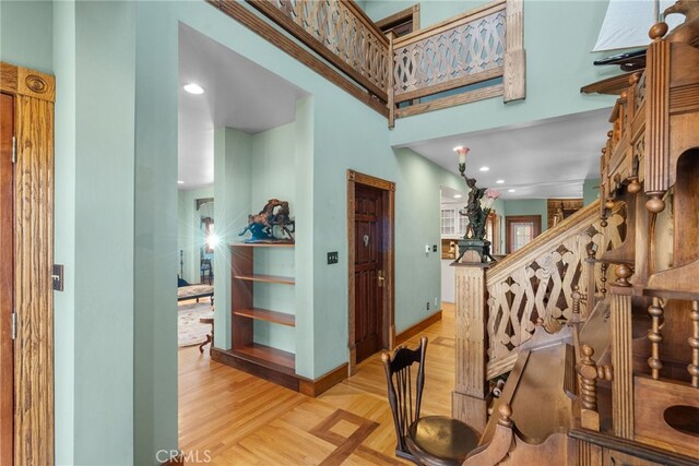 foyer with baseboards, stairs, and parquet floors