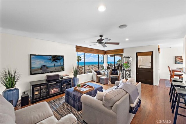 living room with wood-type flooring, recessed lighting, baseboards, and ceiling fan