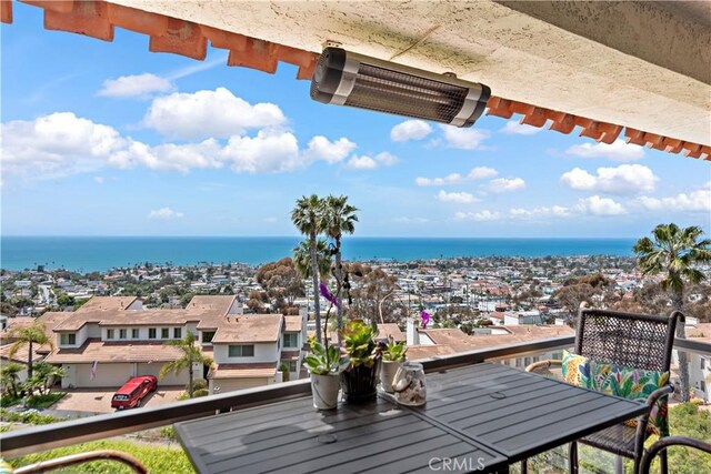balcony featuring visible vents, outdoor dining area, and a water view