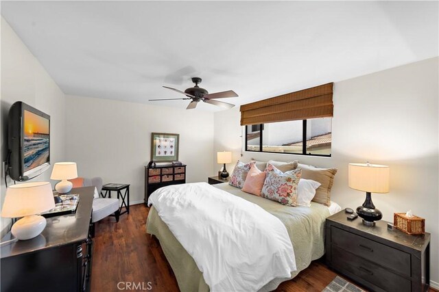 bedroom featuring baseboards, a ceiling fan, and dark wood finished floors