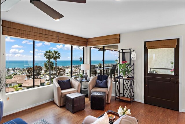 interior space featuring a water view, baseboards, and wood finished floors