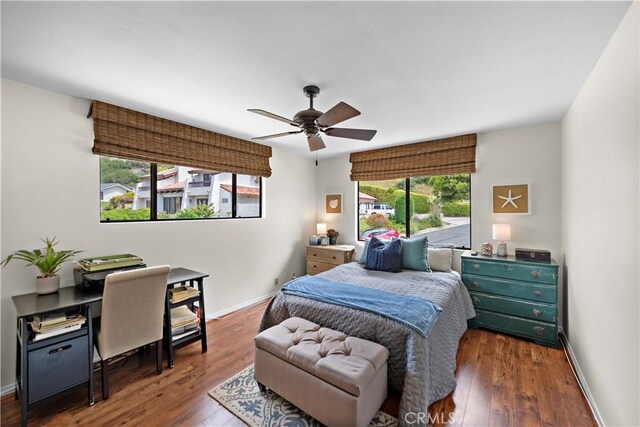 bedroom with baseboards, ceiling fan, and hardwood / wood-style flooring