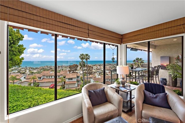 sunroom with a water view and wood finished floors