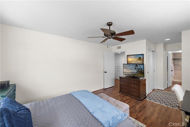 bedroom featuring visible vents, a closet, wood finished floors, baseboards, and a ceiling fan