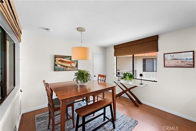 dining space featuring baseboards and wood finished floors