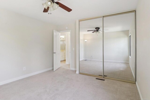 unfurnished bedroom featuring carpet floors, ceiling fan, a closet, and visible vents