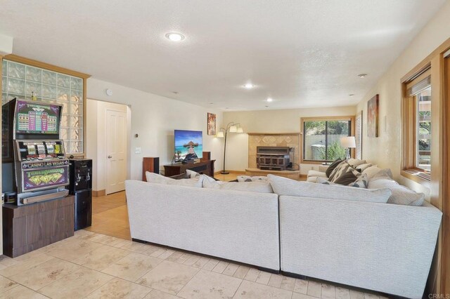 living room with recessed lighting, light tile patterned flooring, and a tile fireplace