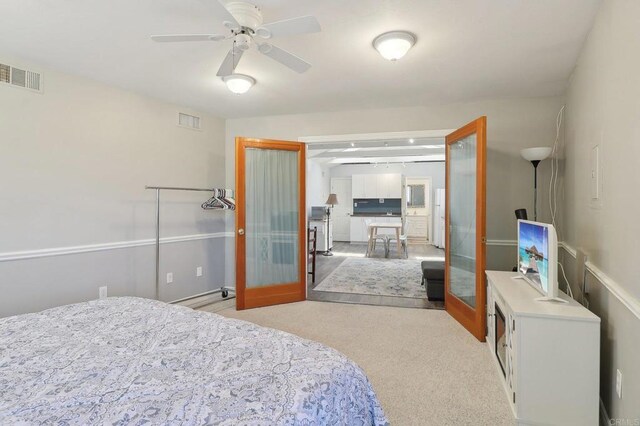 bedroom with a ceiling fan, visible vents, and light carpet