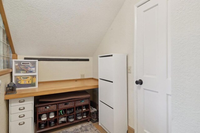 interior space with a textured ceiling and lofted ceiling